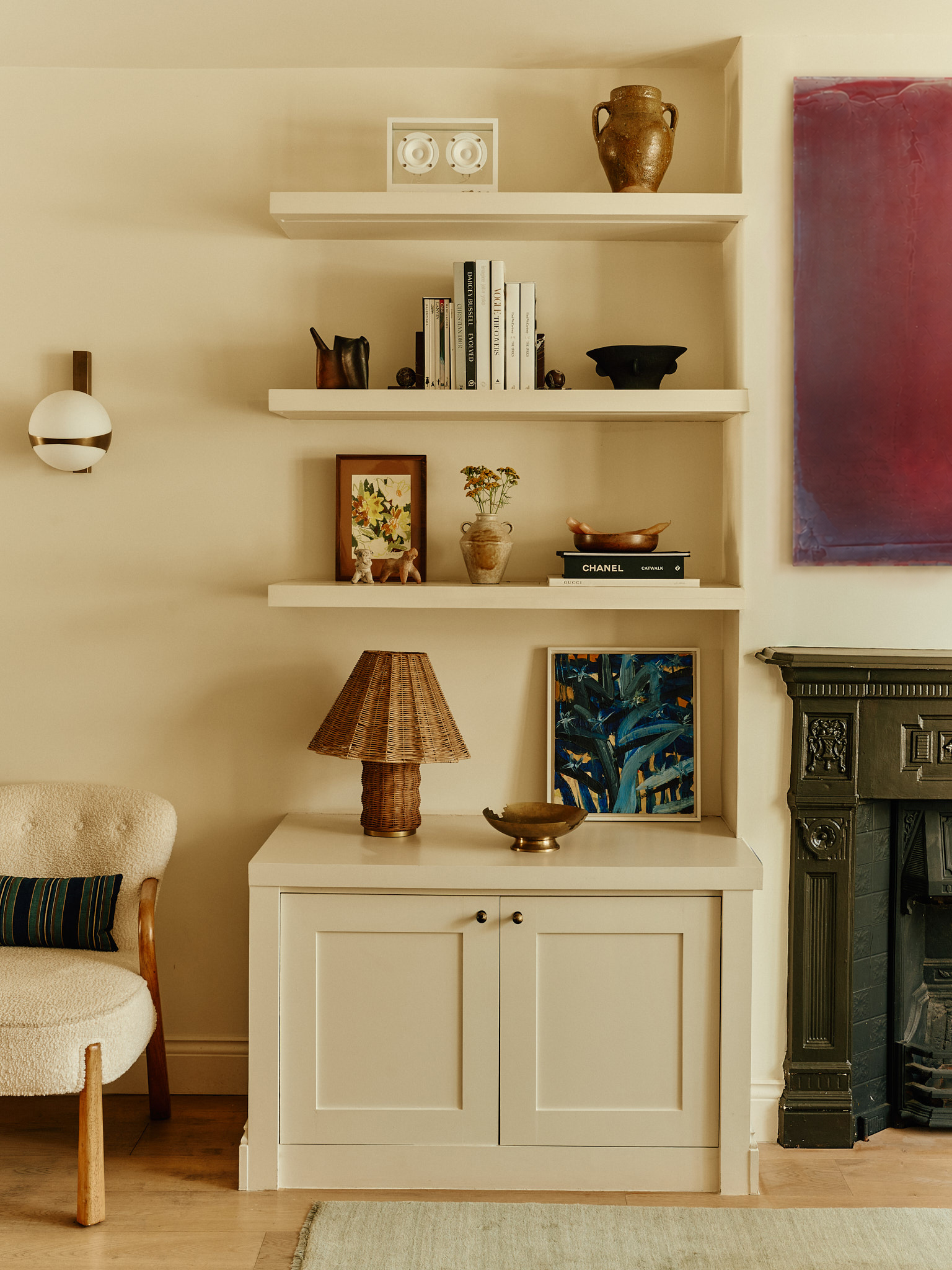 Collected ceramics, books and framed art on living room shelves at School House